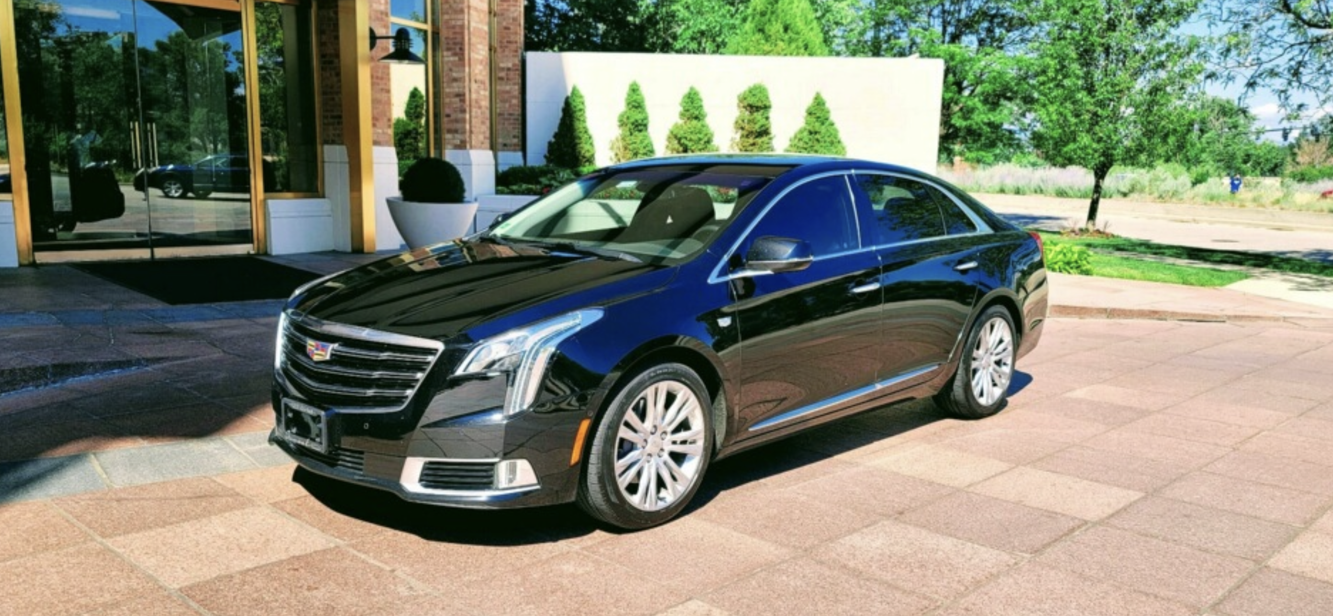 An image of a black cadillac XTS sedan. It's very reflective and looks great.