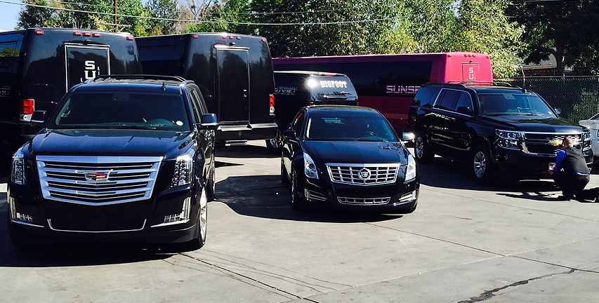 Three black reflective limos being cleaned by a great employee