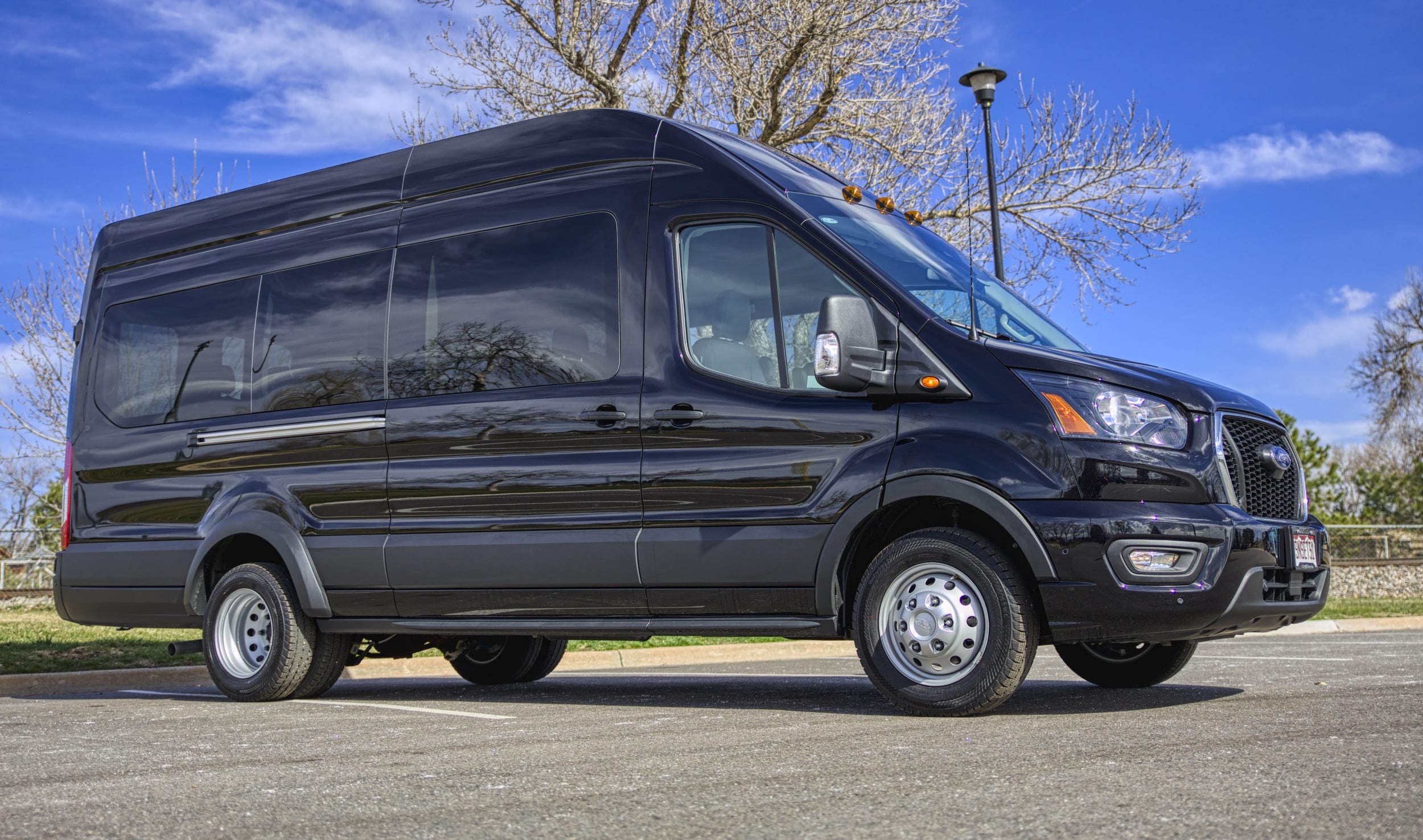A light gray executive van with dark windows and tires.